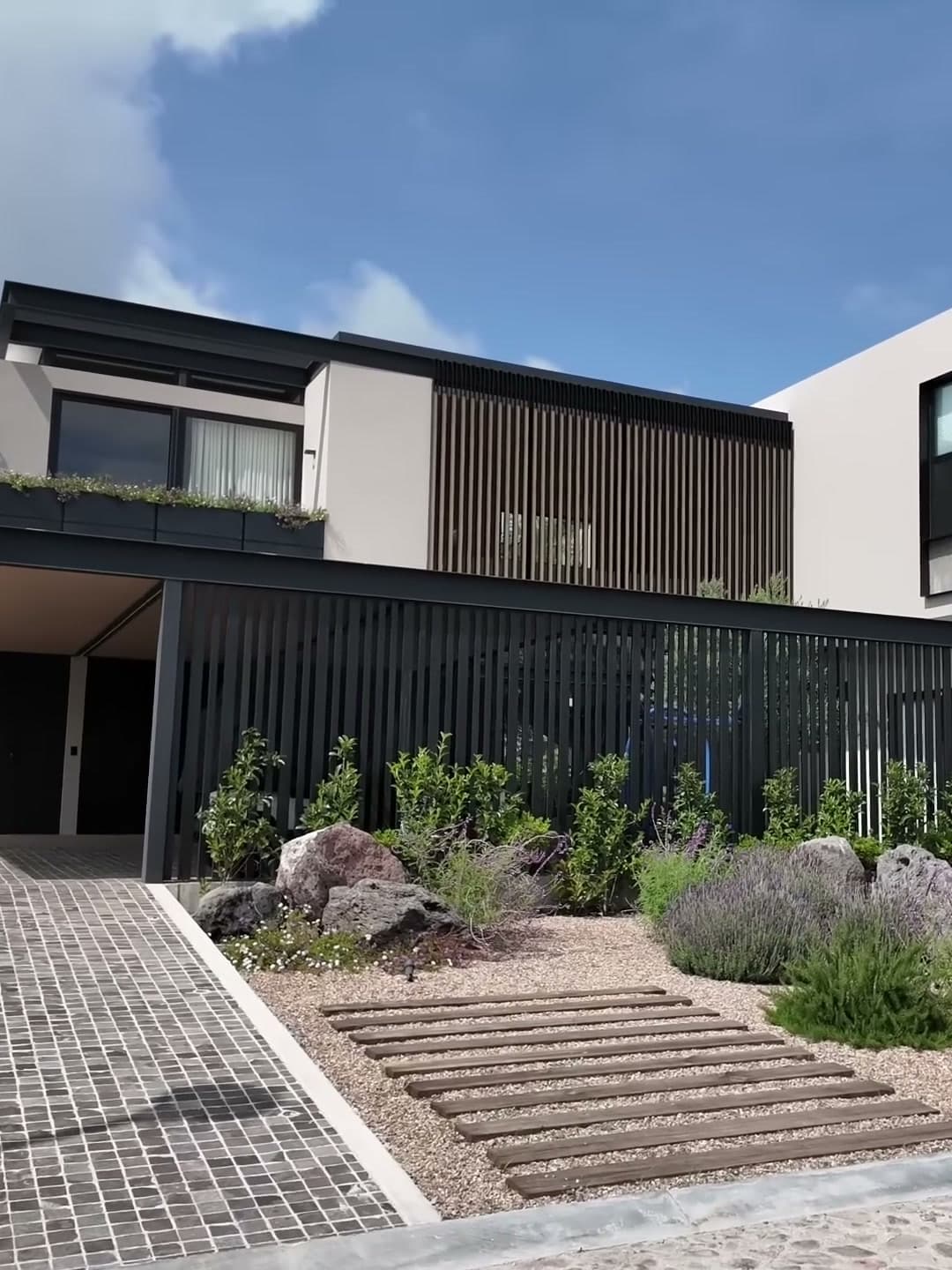 Fachada de casa contemporánea con celosía metálica, concreto aparente y jardín de bajo consumo, en uno de los recorridos de obra de El Arqui Diego